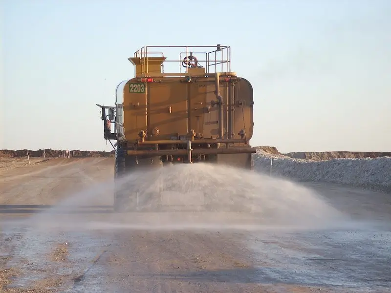 Hydroseeding Auckland and Hydroseeding North Shore – dust suppression truck spraying water on a dirt road for air quality control